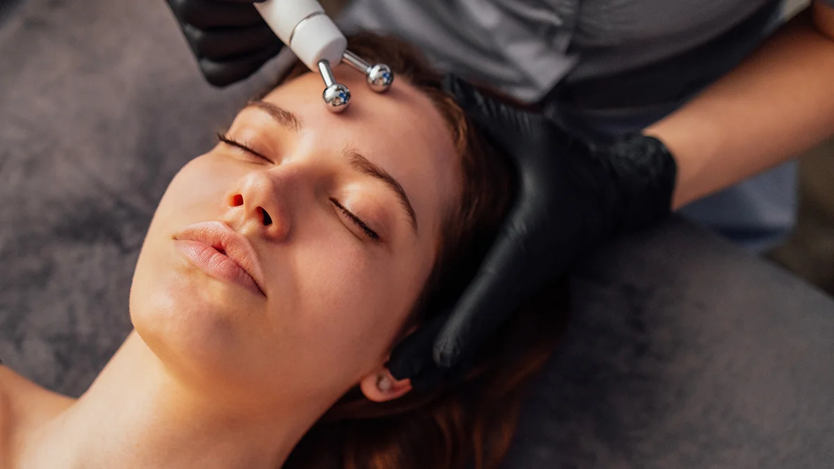 A woman enjoying a microcurrent facial and microcurrent benefits